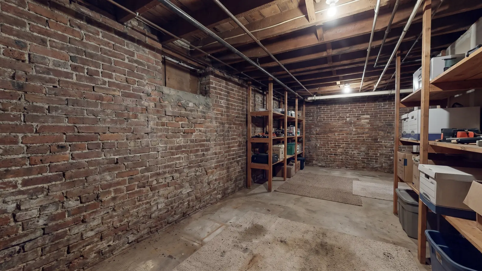 The brick foundation wall of an older Edmonton home, seen from inside an unfinished basement
